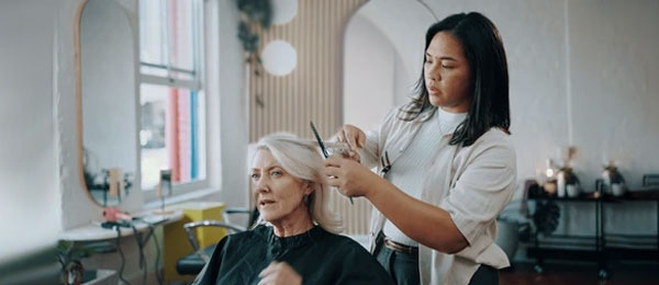 hairdresser inspecting client's hair in salon